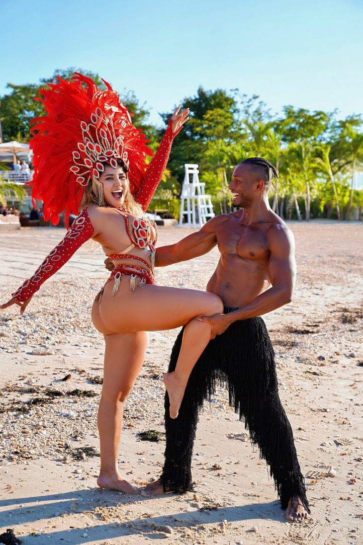 Carnival couple dancing on the beach in red and black costuming
